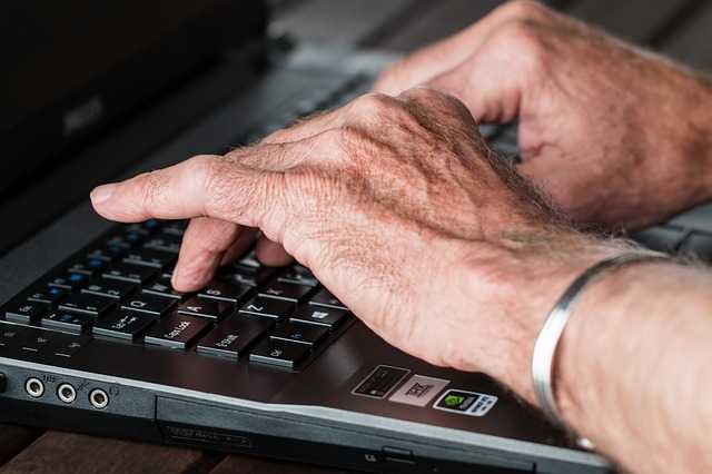 Ρευματοειδής Αρθρίτιδα - αρθρώσεις - άντρας πληκτρολογεί σε laptop